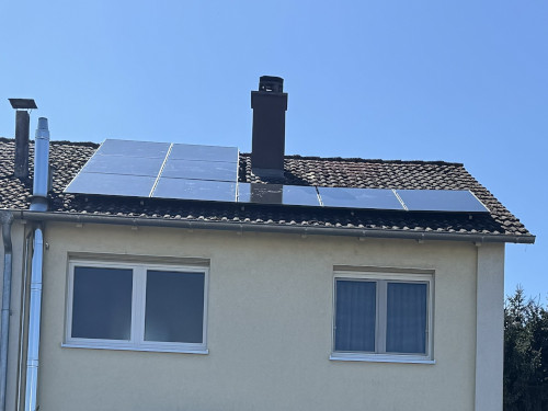 Eine Photovoltaik-Anlage auf dem Hausdach mit Kamin.